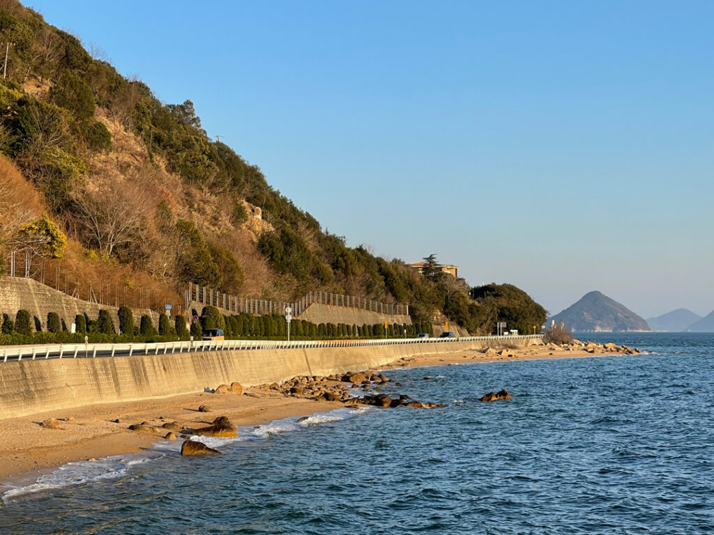 地形に沿ってゆるやかなワインディングが続く道。対岸の香川県高松市の市街地までよく見える。