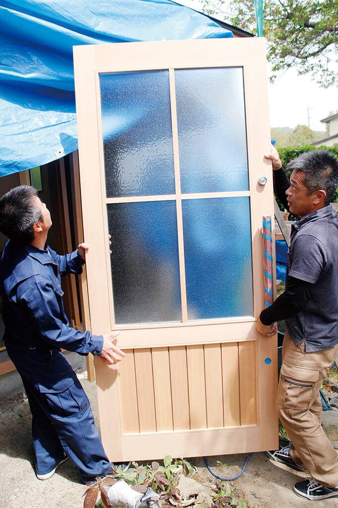 引き戸を運び入れる建具職人の石井さん