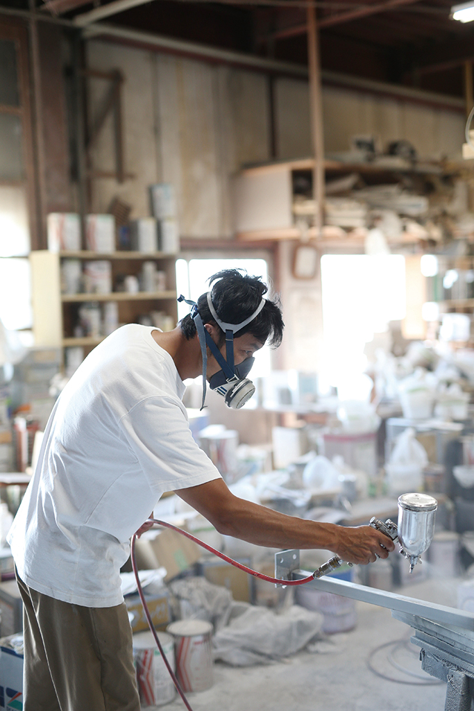 マスクを付けて作業する家具職人藤原秀人