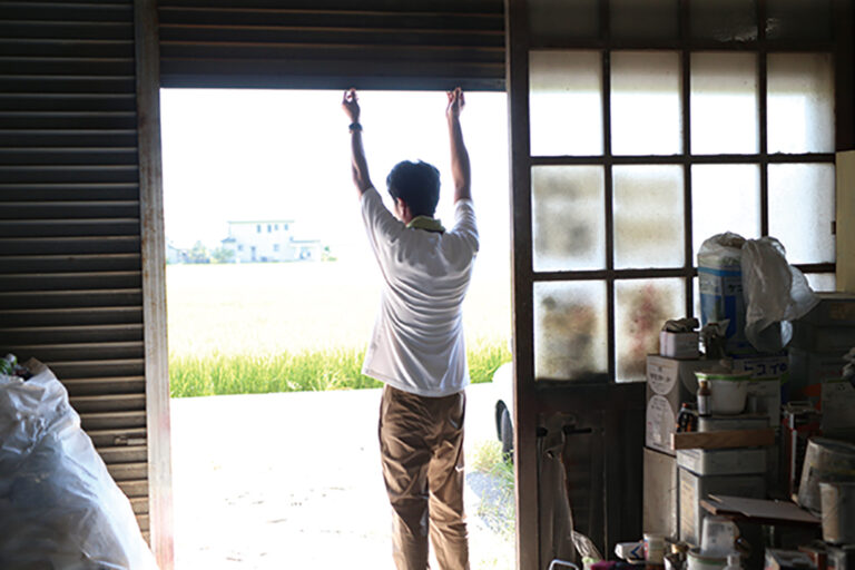 シャッターを開ける家具職人藤原秀人