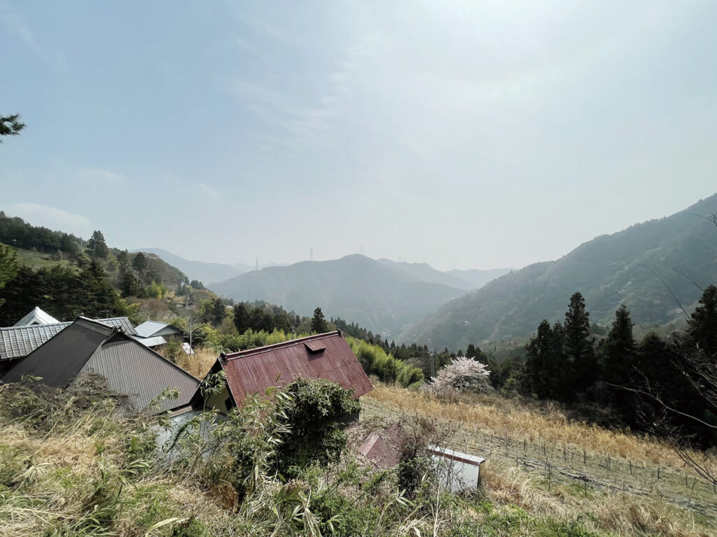 奥の湯ふれあいの里を出発し、標高300ｍほどの地点。春の陽気に包まれた山間の風景をしばし眺める。ここまでですでに額や背中に汗がにじむ。